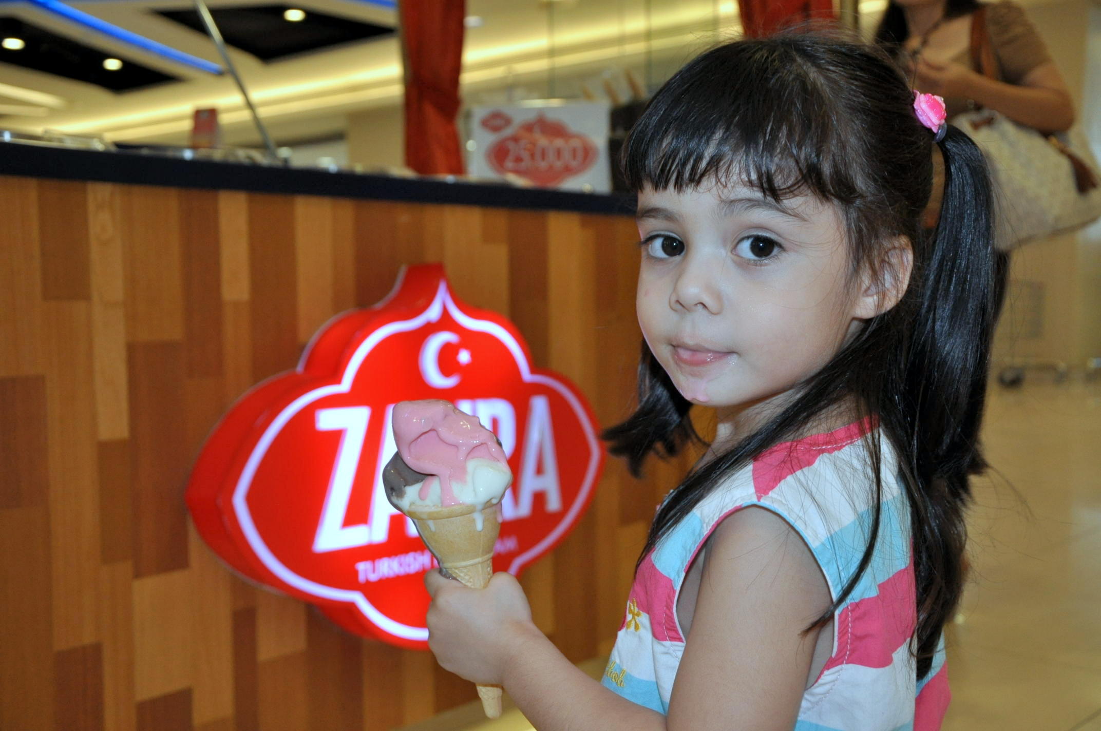 Child enjoying ice cream at Zahra counter